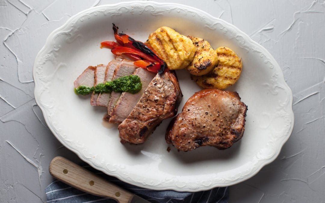 Oak Smoked Pork Chops with Arugula Pesto, Charred Peppers and Grilled Polenta